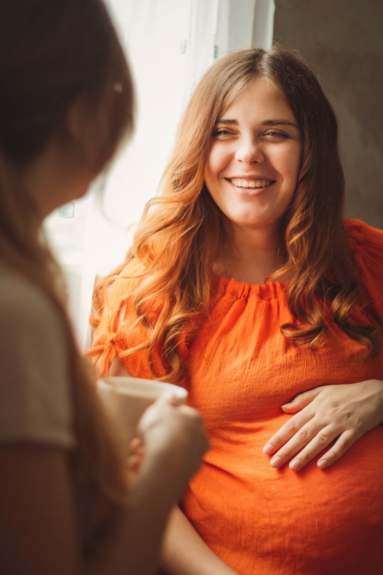 Two,Young,Sisters,Sitting,In,Kitchen,Drinking,Tea,And,Talking